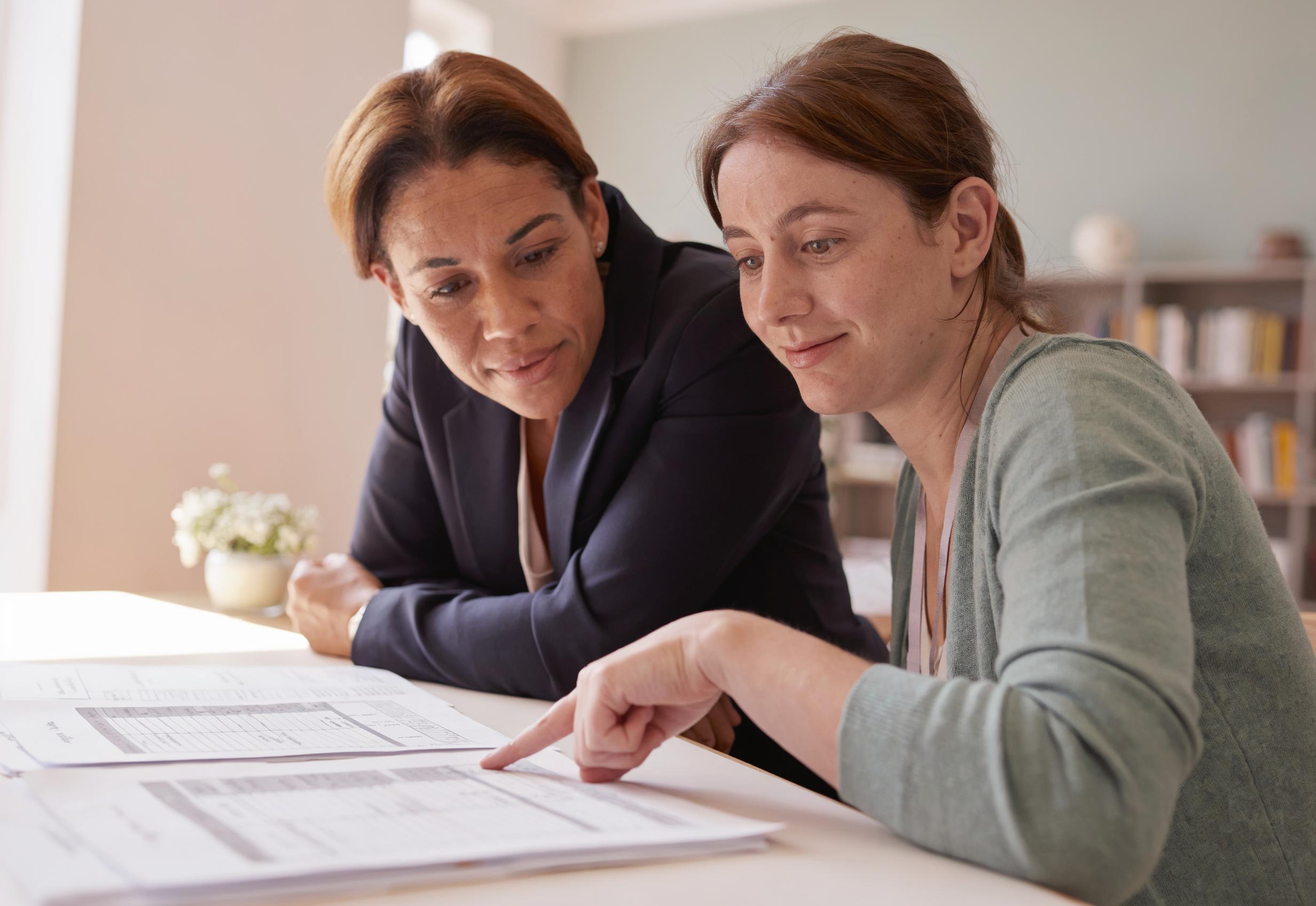 A parent and a Florida-certified evaluator reviewing the student's portfolio together